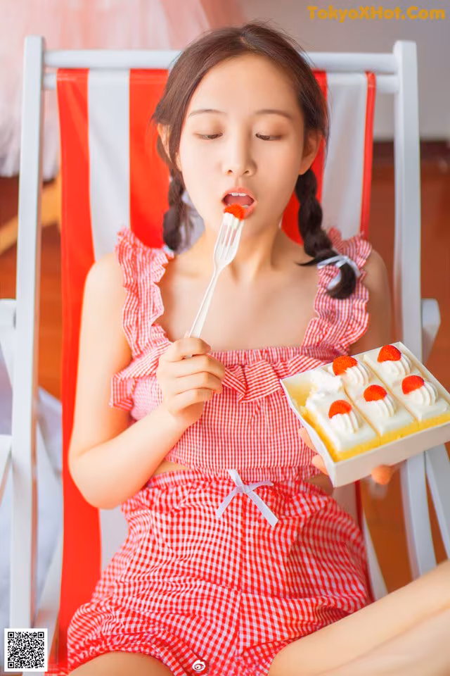 A woman sitting in a chair eating a piece of cake.