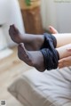 A woman in black stockings is sitting on a couch.