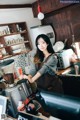 A woman standing behind a counter in a coffee shop.