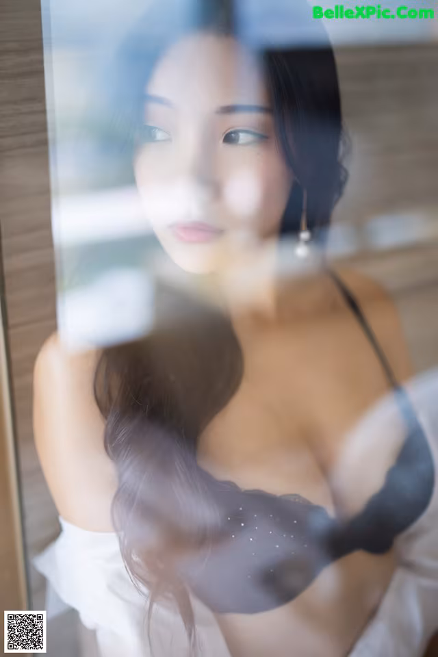 A woman in lingerie looking out of a window.
