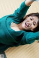 A woman laying on the floor with her arms outstretched.