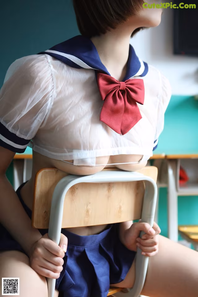 A woman in a school uniform sitting on a chair.