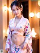 A woman in a pink kimono posing for the camera.