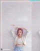 A magazine with a picture of a girl with pink hair.
