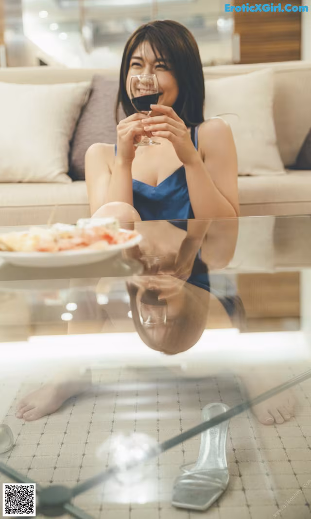 A woman sitting on a couch holding a glass of wine.