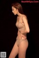 A woman in a beige lingerie posing for a picture.