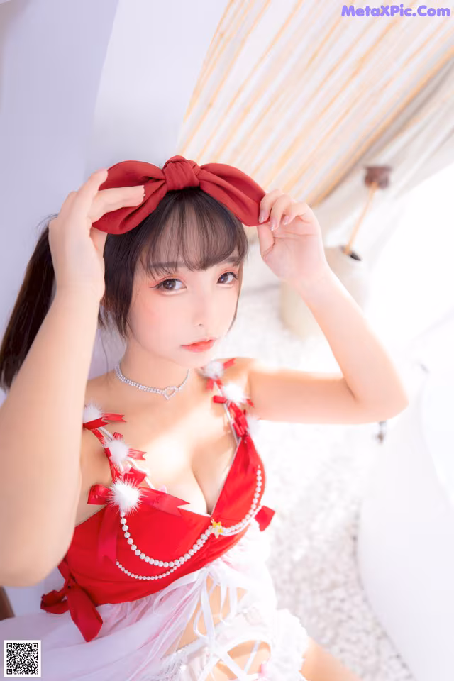 A woman in a red and white lingerie posing for a picture.