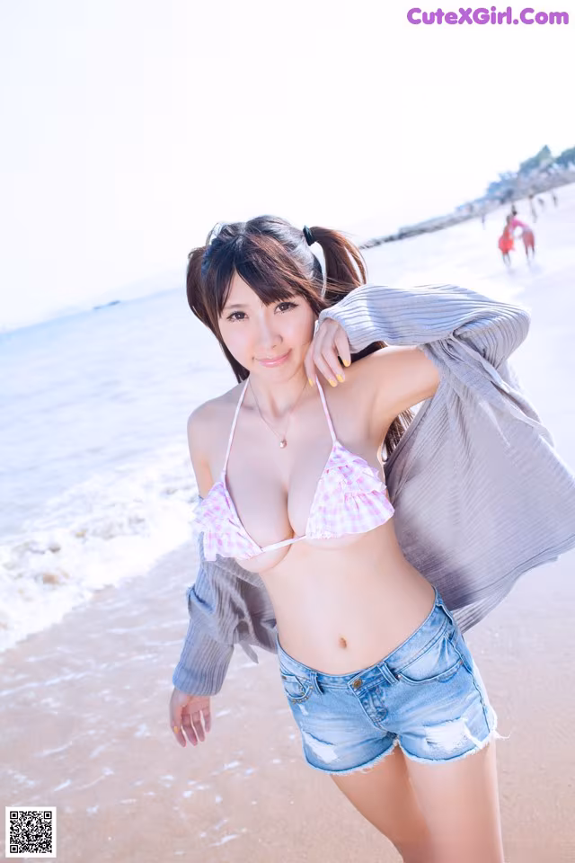 A woman in a bikini standing on a beach.
